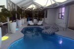 Lit heated pool and lanai at dusk — Canal Villa