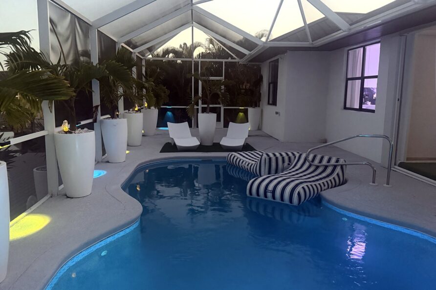 Lit heated pool and lanai at dusk — Canal Villa