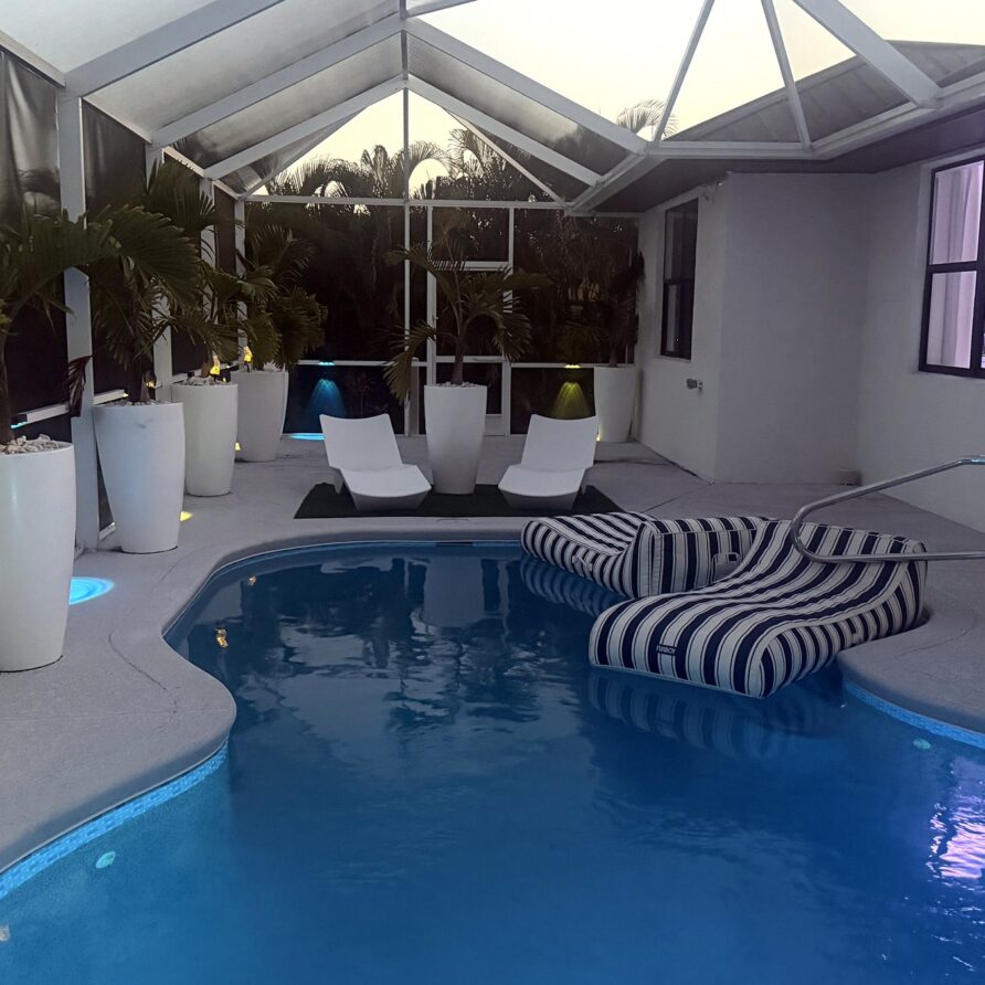 Lit heated pool and lanai at dusk — Canal Villa
