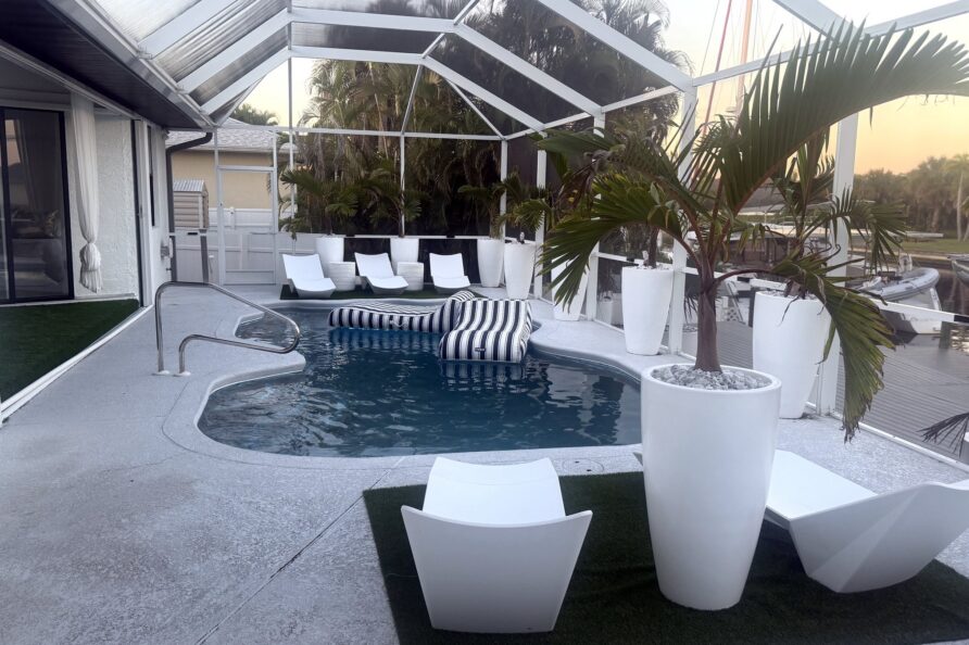 Pool loungers and canal view at sunset — Canal Villa