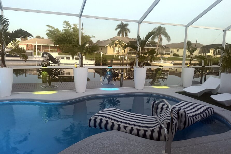 Striped pool lounger with evening lights — Canal Villa