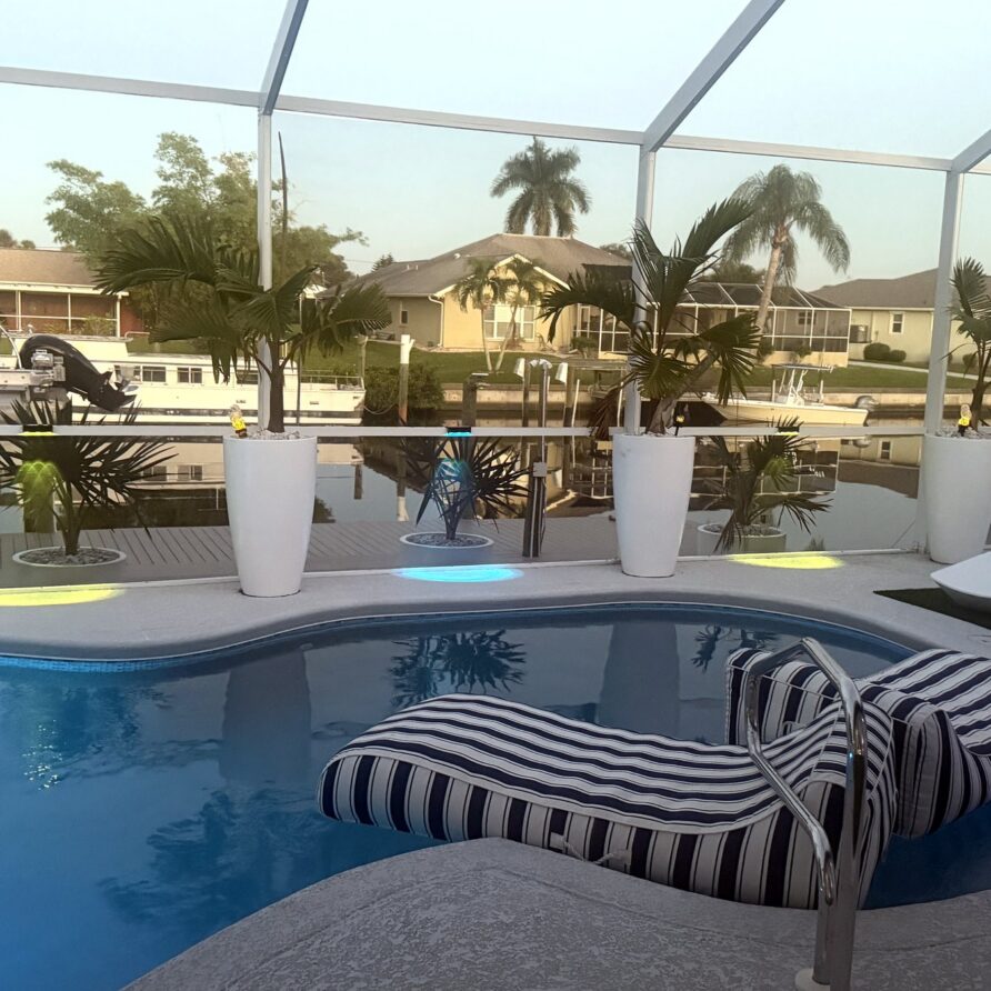 Striped pool lounger with evening lights — Canal Villa