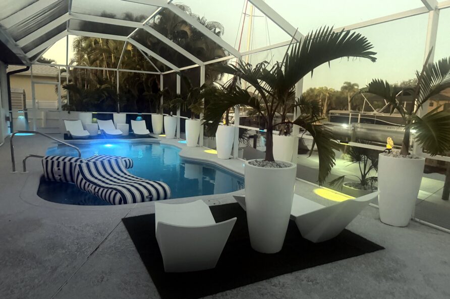 Pool with designer loungers and planters at dusk — Canal Villa