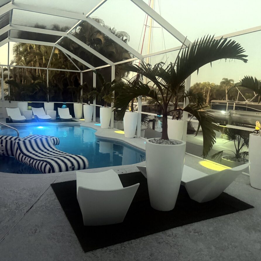 Pool with designer loungers and planters at dusk — Canal Villa