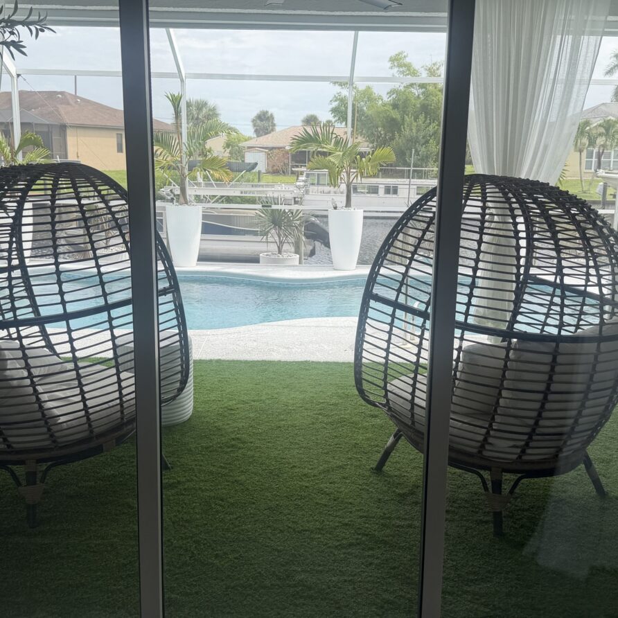 Screened lanai with egg-chairs opening to the pool and canal